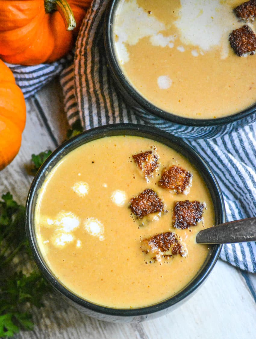 Easy Pumpkin Soup With Cinnamon Croutons pumpkin soup in black bowls topped with cinnamon sugar croutons