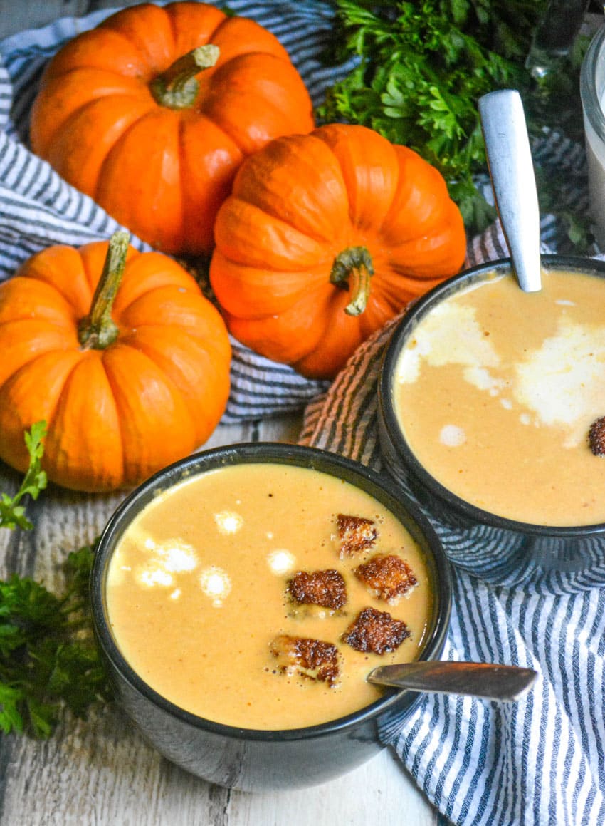 pumpkin soup in black bowls topped with cinnamon sugar croutons