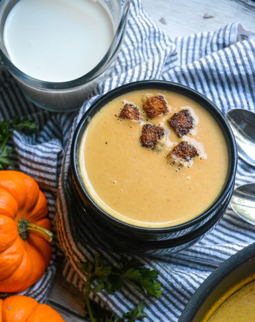 pumpkin soup in black bowls topped with cinnamon sugar croutons