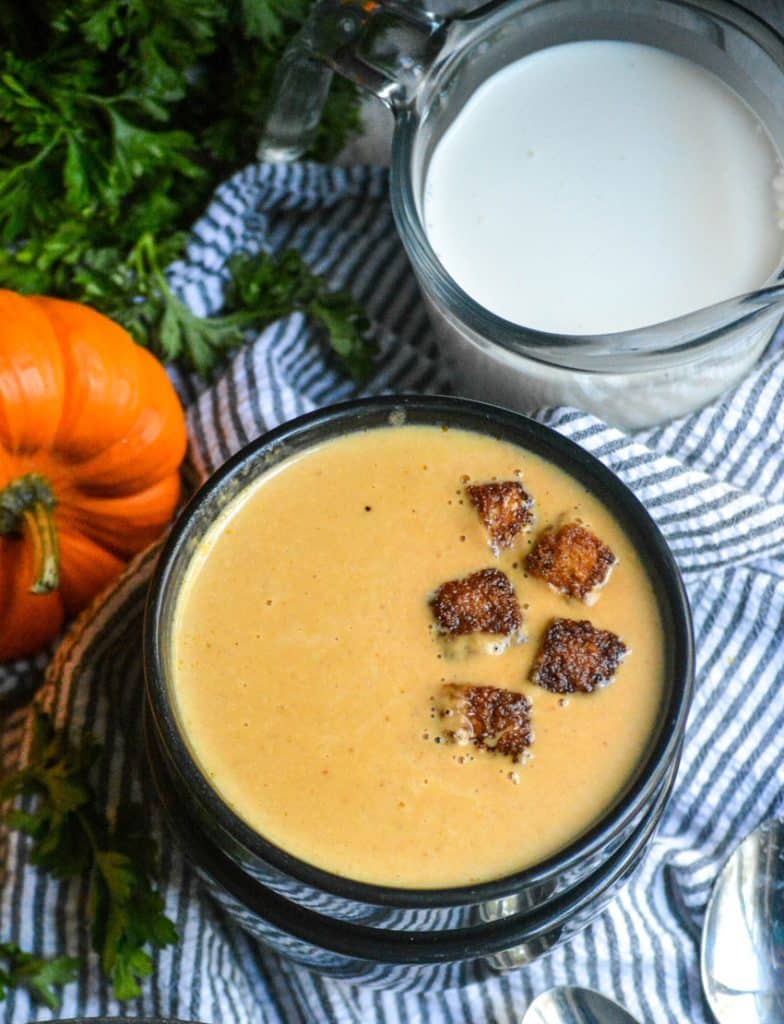 pumpkin soup in black bowls topped with cinnamon sugar croutons