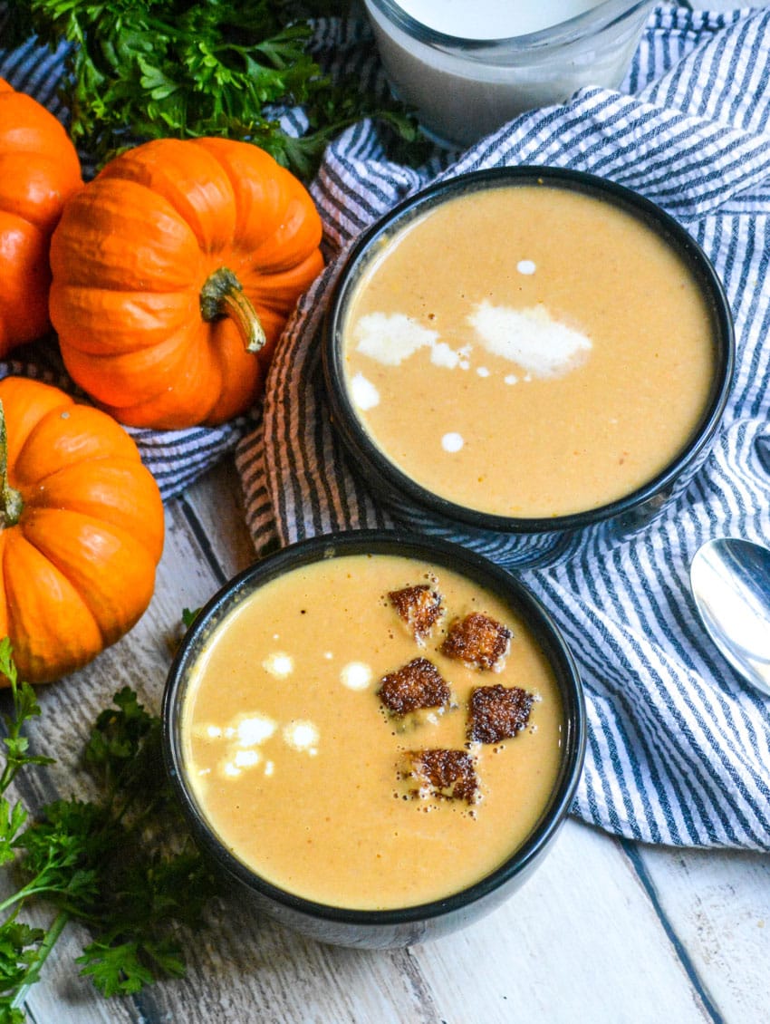 pumpkin soup in black bowls topped with cinnamon sugar croutons