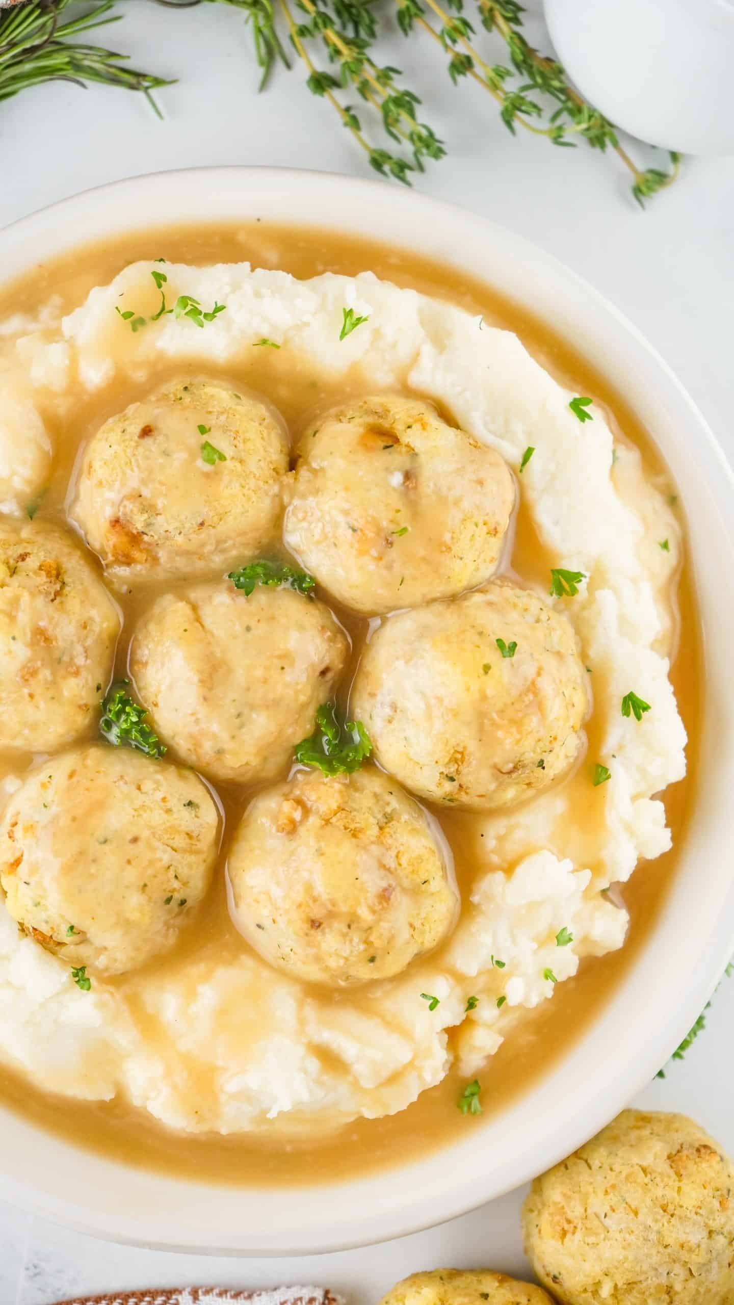 leftover turkey meatballs on a bed of mashed potatoes covered in brown gravy and sprinkled with herbs