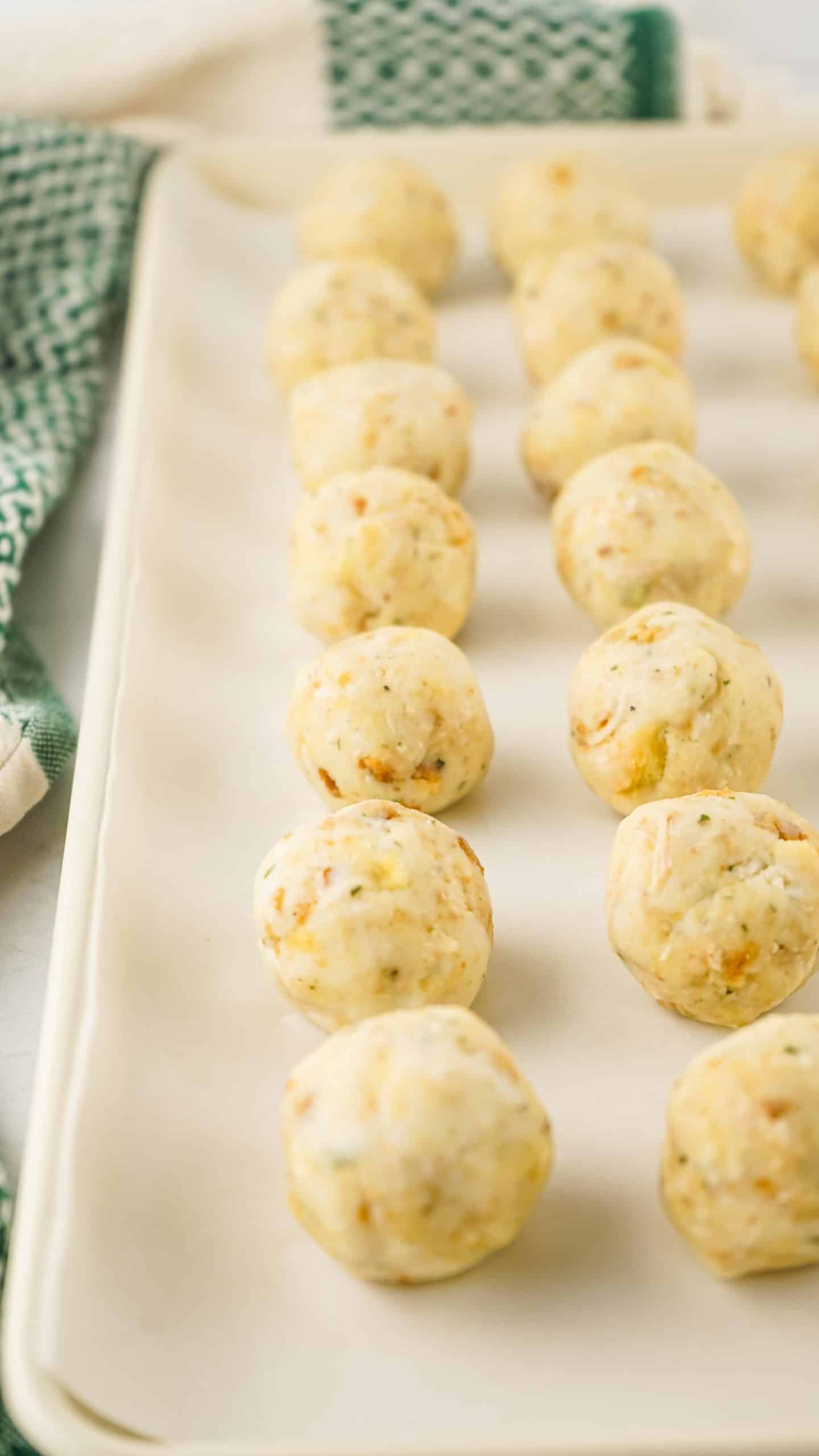 thanksgiving leftover turkey meatballs arranged in rows on a parchment paper lined baking tray