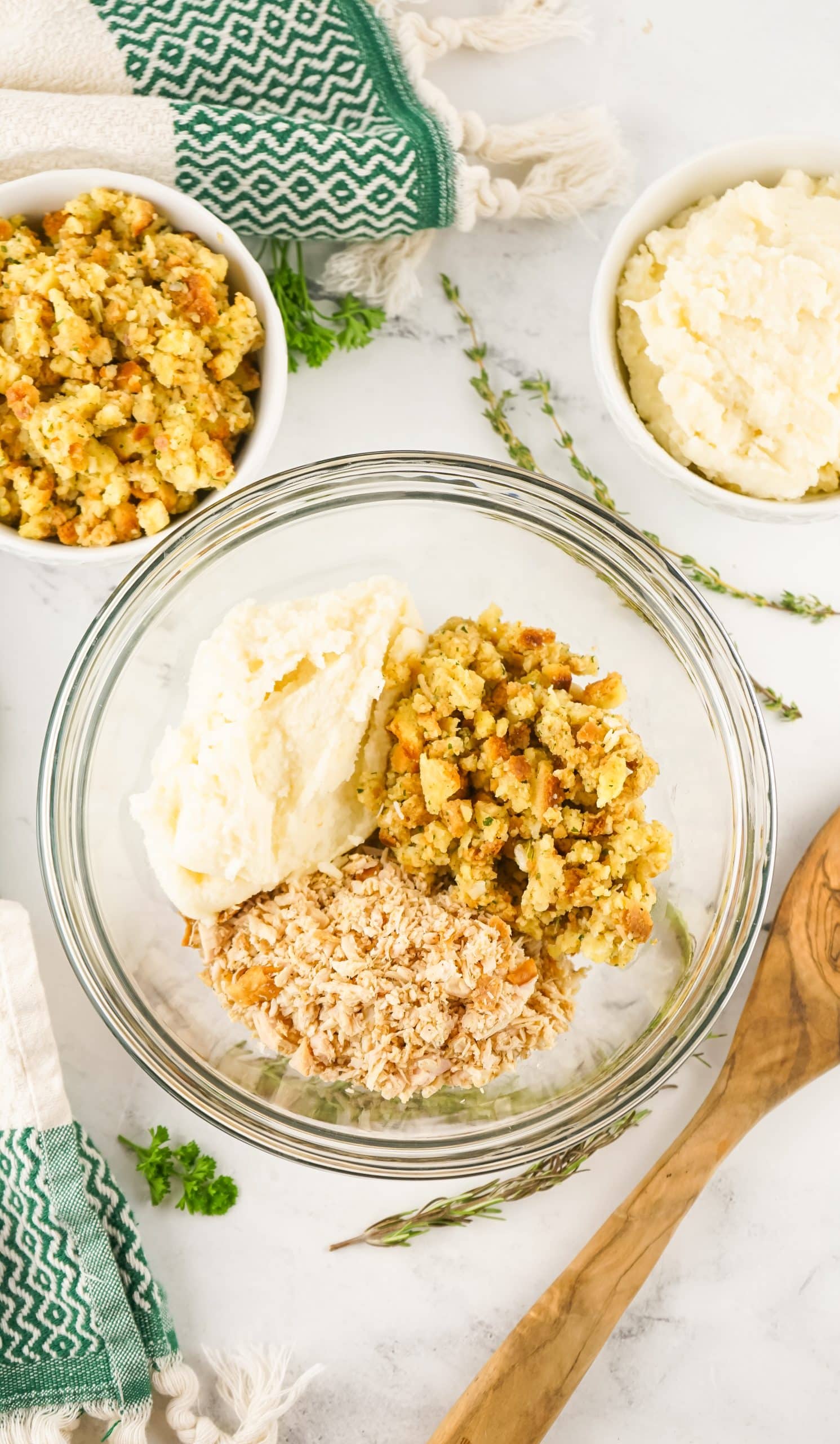 leftover mashed potatoes, stuffing, and minced turkey in a glass mixing bowl