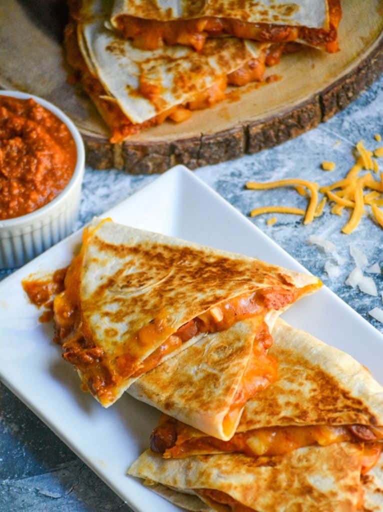 slices of chili cheese dog quesadillas on a white serving platter