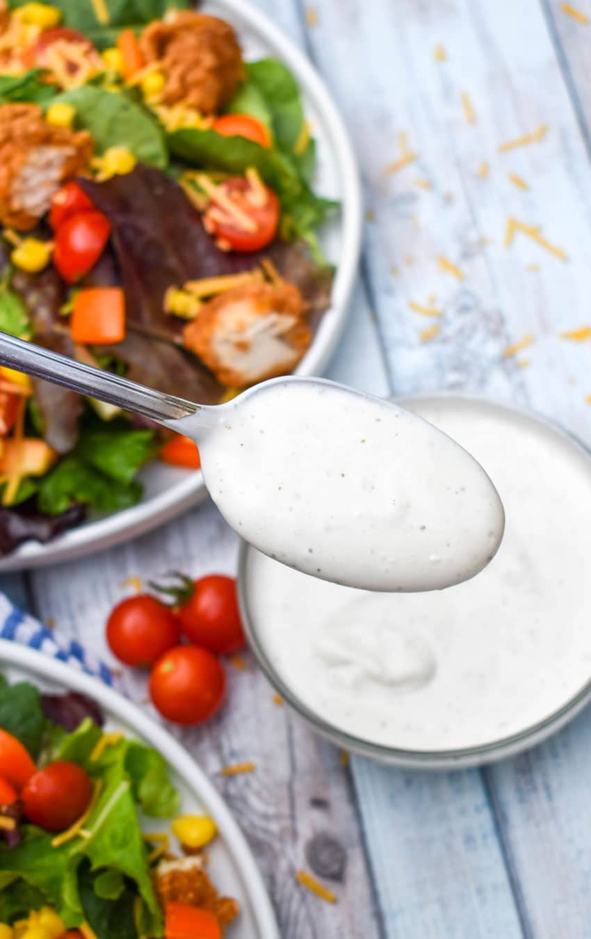 a silver spoon lifting up a scoop of cottage cheese ranch dressing