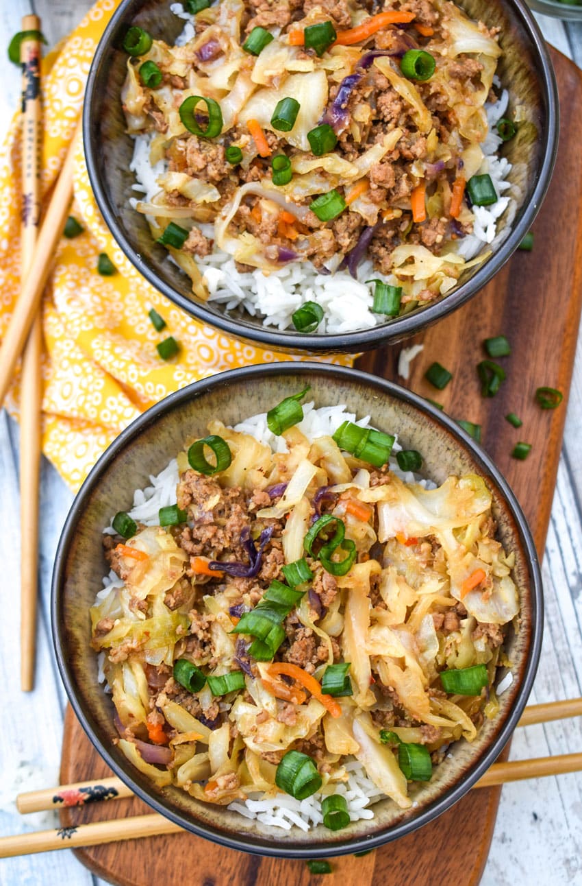 instant pot egg roll in a bowl sitting on a wooden cutting board with chop sticks on the side