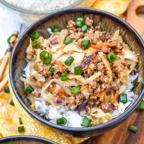 instant pot egg roll in a bowl sitting on a wooden cutting board with chop sticks on the side