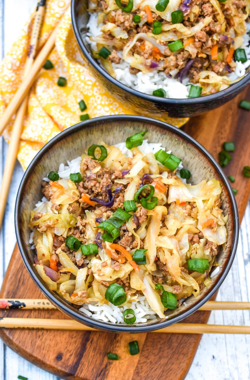 instant pot egg roll in a bowl sitting on a wooden cutting board with chop sticks on the side