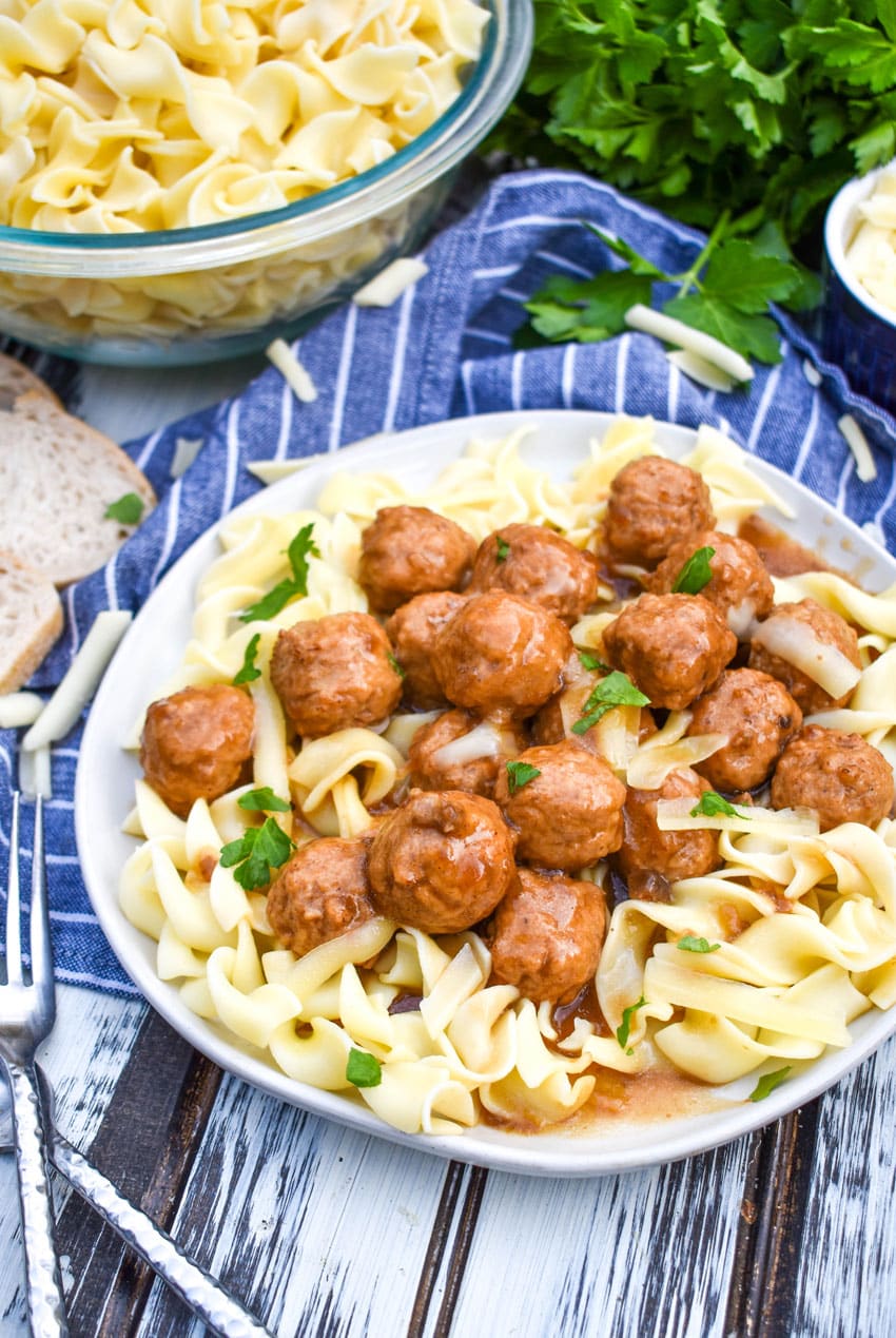 instant pot french onion meatballs over egg noodles on a white plate