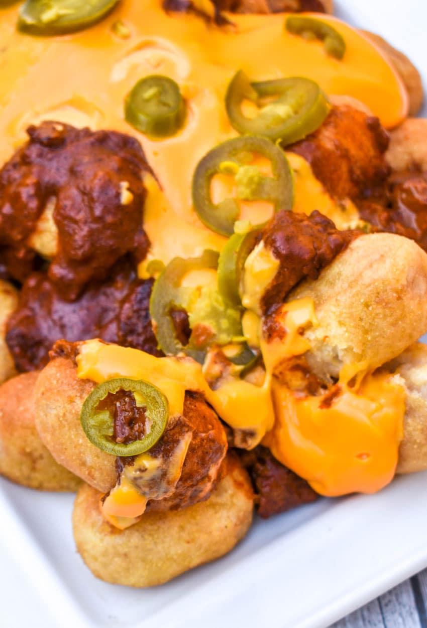 loaded corn dog nugget nachos on a white serving platter