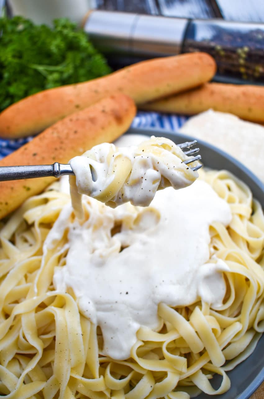 Easy Homemade Alfredo Sauce Recipe homemade alfredo sauce and noodles wrapped around the tines of a silver fork