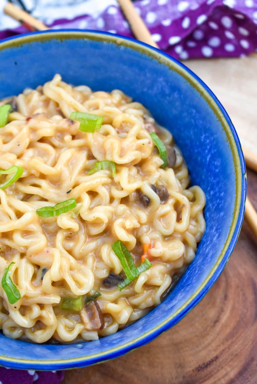 shaq ramen noodle hack recipe in a blue bowl with wooden chop sticks on the side