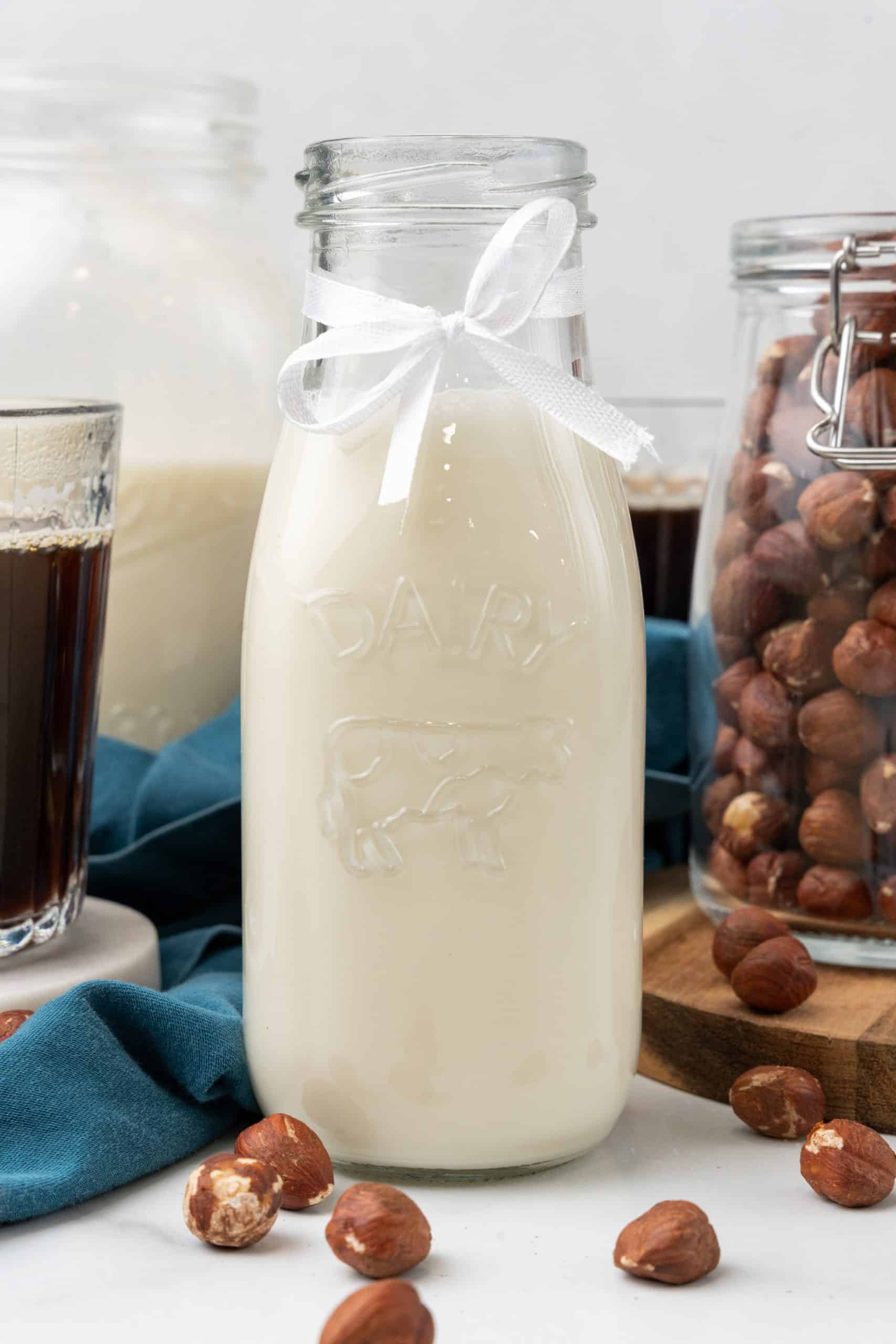 homemade hazelnut coffee creamer in a glass jar on a marble coaster