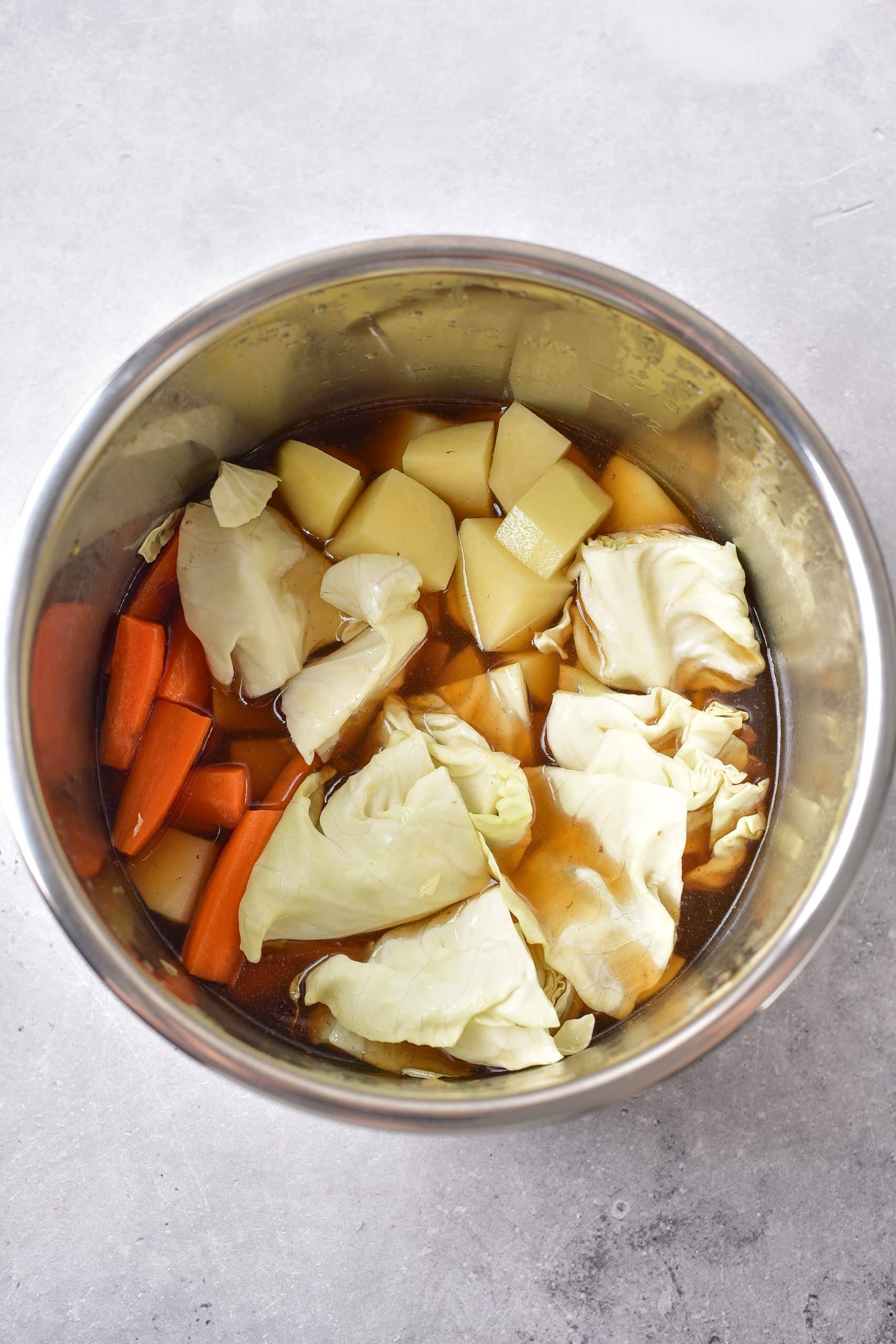 cabbage, carrots and potatoes in the bowl of an instant pot
