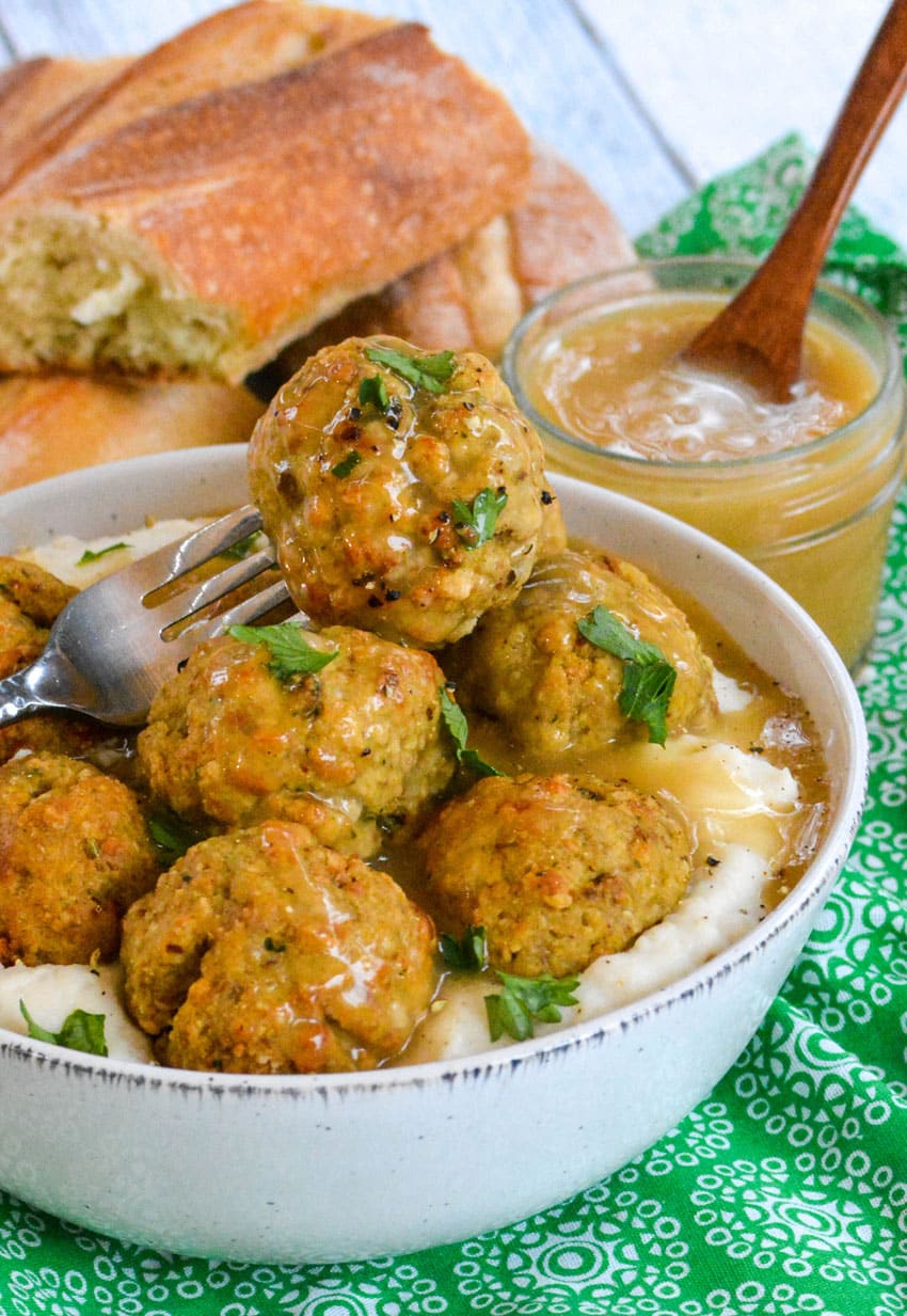 easy chicken meatballs with stuffing mix in a white bowl with mashed potatoes and gravy
