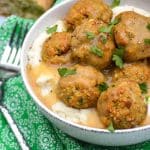 easy chicken meatballs with stuffing mix in a white bowl with mashed potatoes and gravy