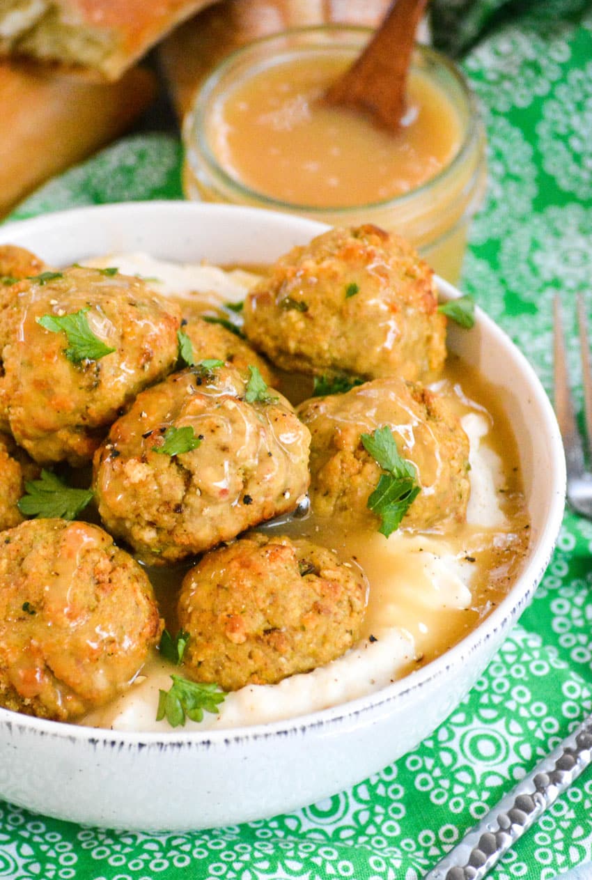 easy chicken meatballs with stuffing mix in a white bowl with mashed potatoes and gravy