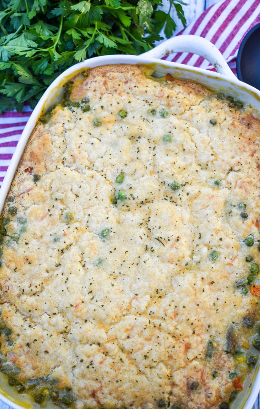 easy chicken cobbler with vegetables in a white casserole dish