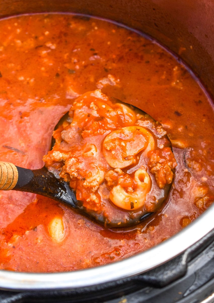 a black ladle scooping pizza soup out of an instant pot