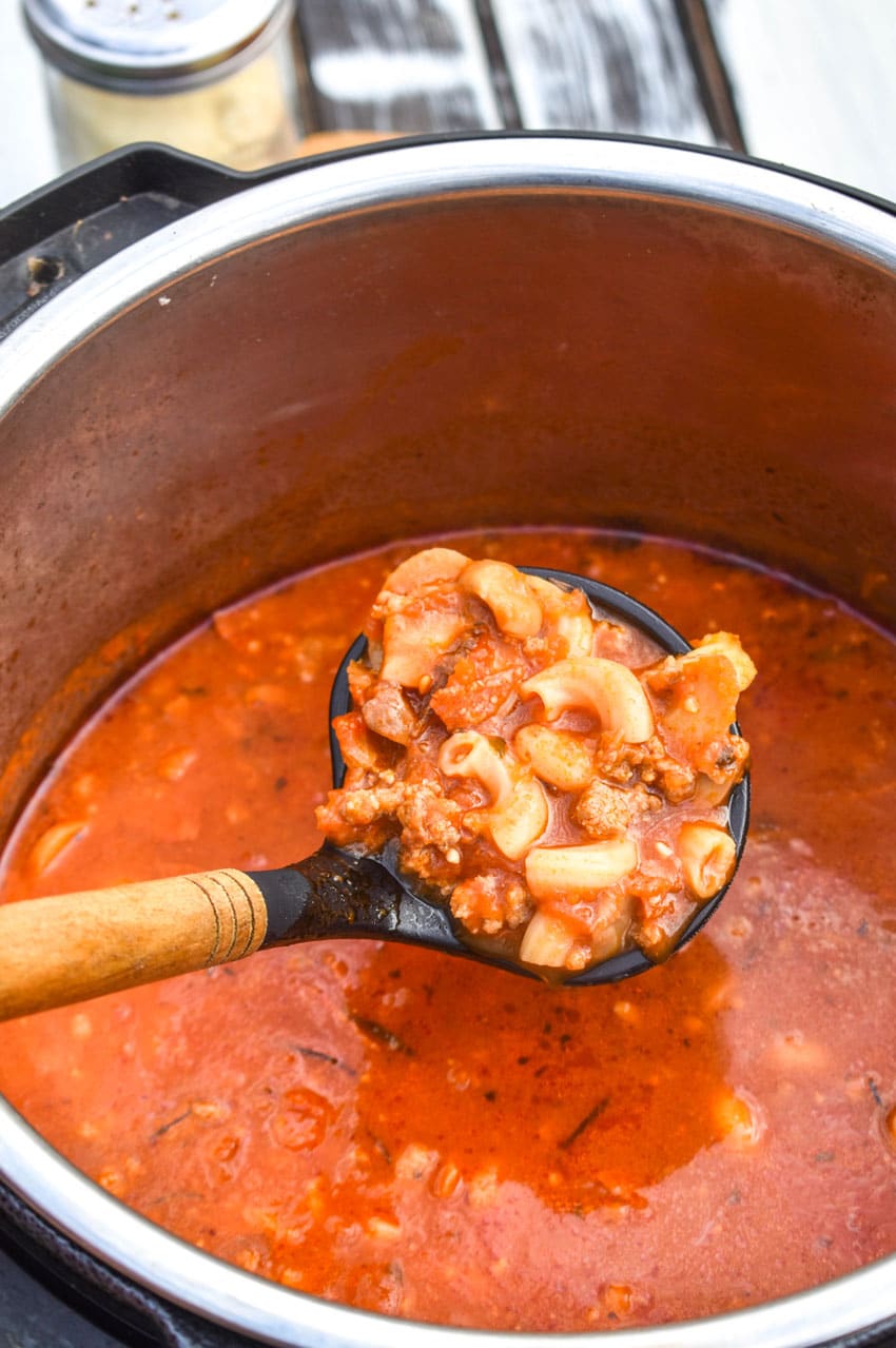 a black ladle scooping pizza soup out of an instant pot