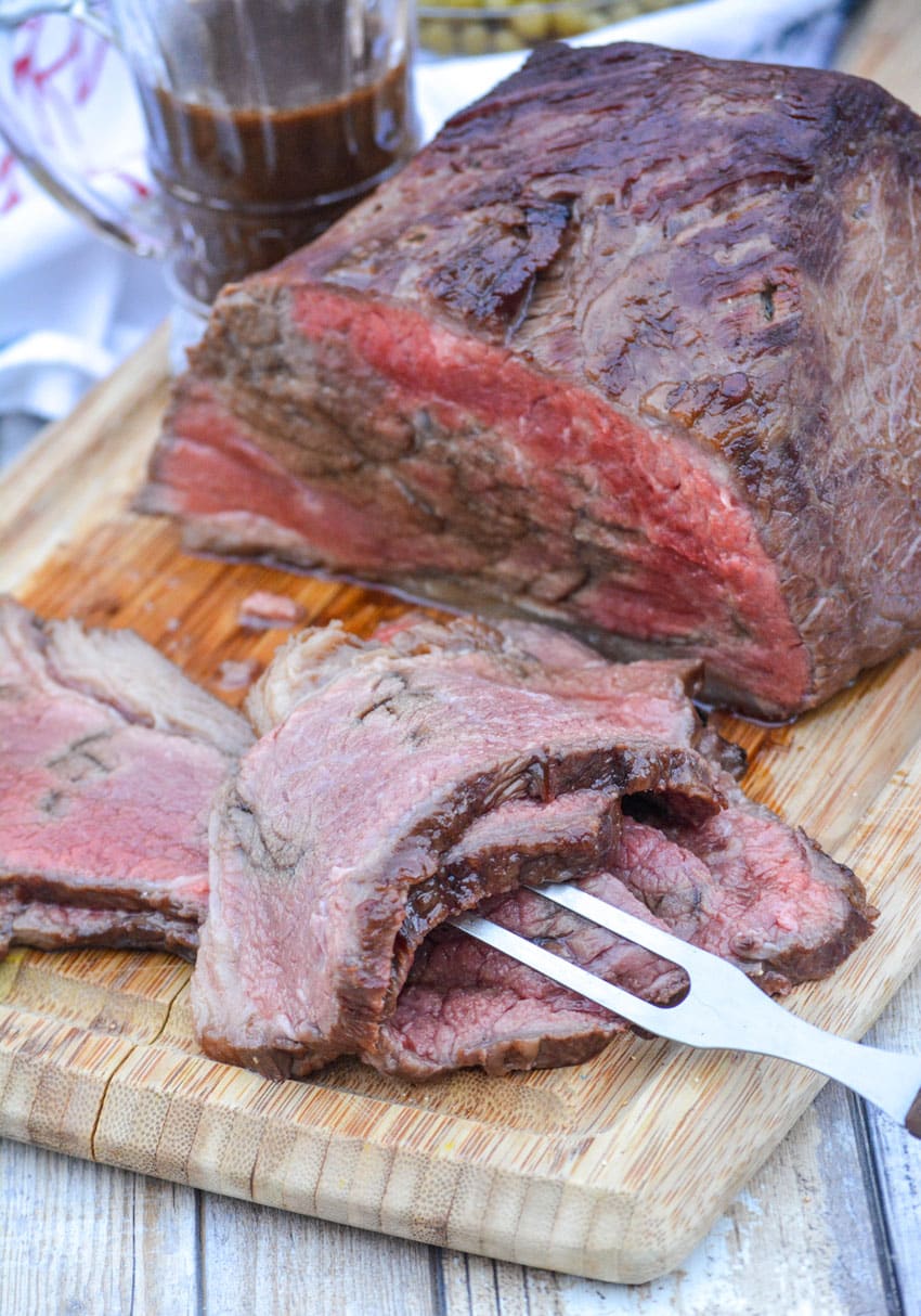 slices of worcestershire marinaded bottom round roast on a wooden cutting board
