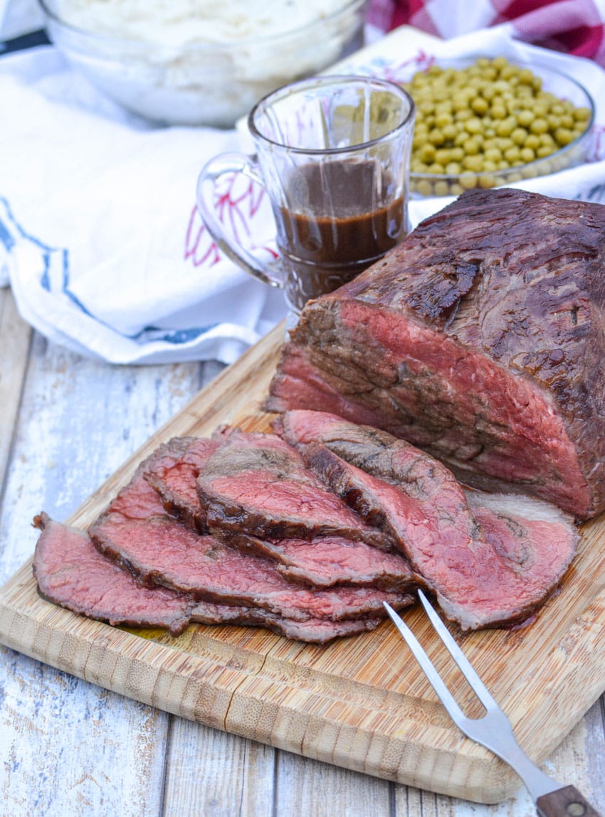 slices of worcestershire marinaded bottom round roast on a wooden cutting board