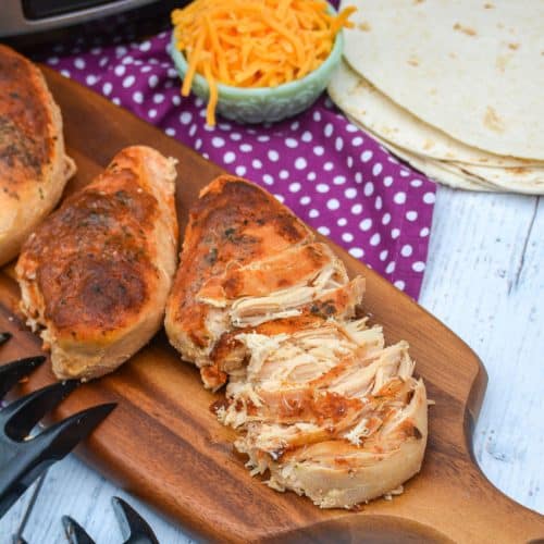 slow cooker cool ranch chicken on a wooden cutting board