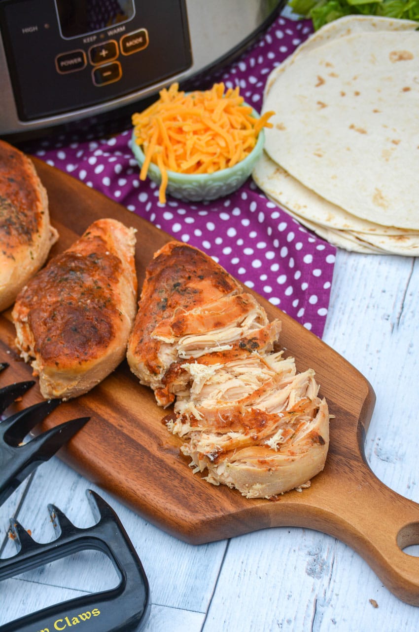 slow cooker cool ranch chicken on a wooden cutting board