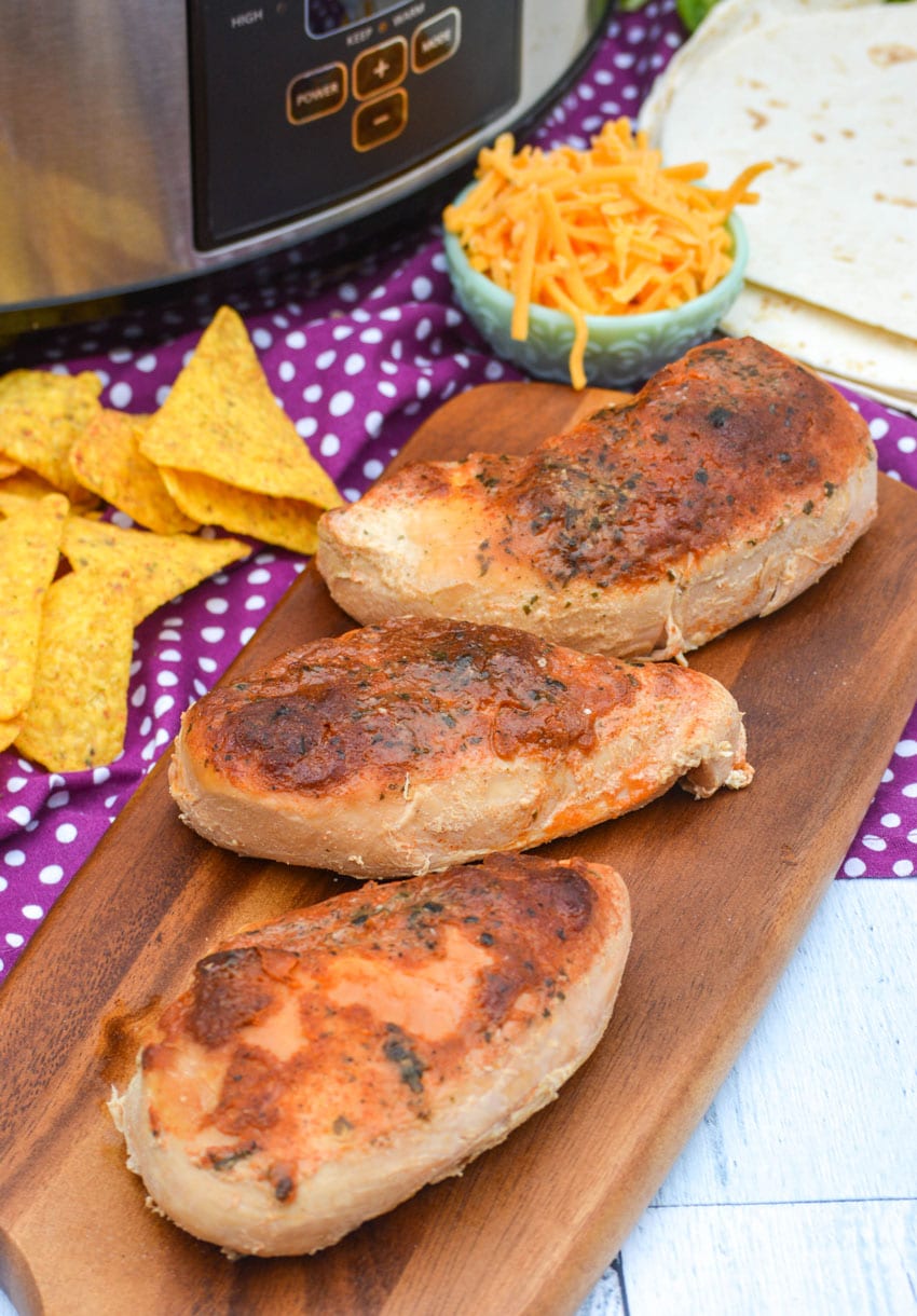 slow cooker cool ranch chicken on a wooden cutting board