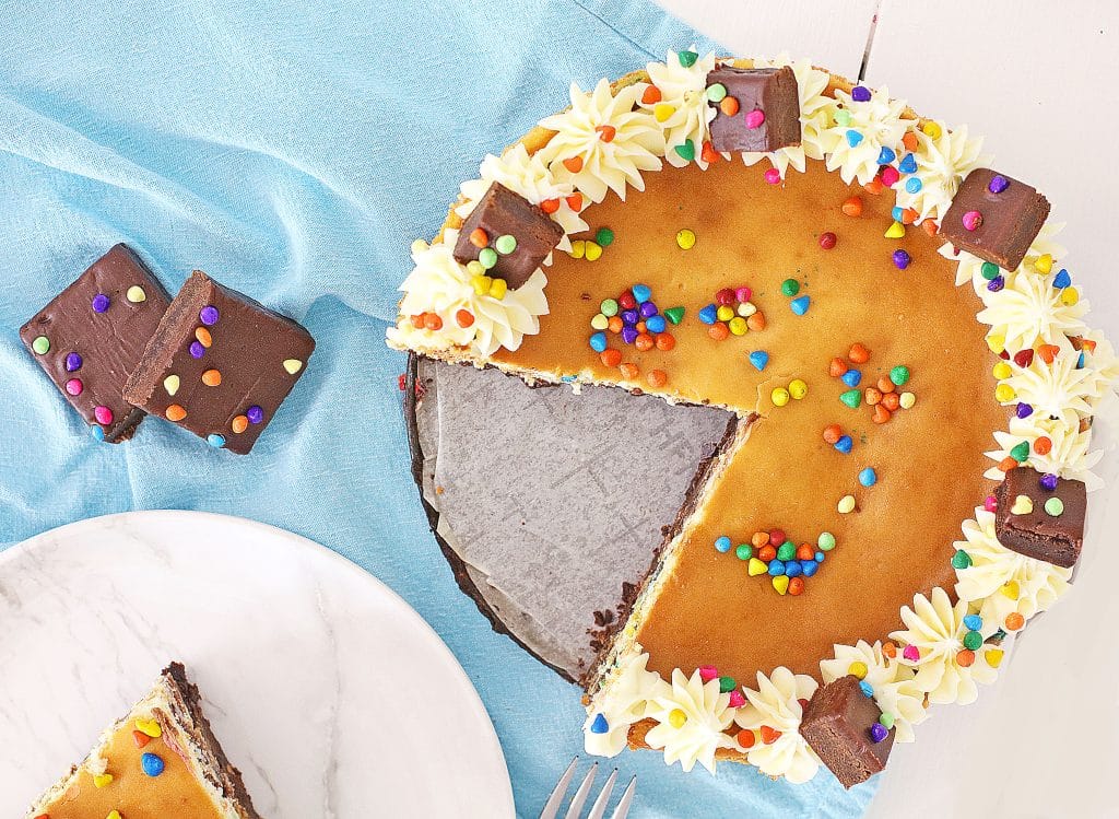 a cosmic brownie cheesecake with a slice removed
