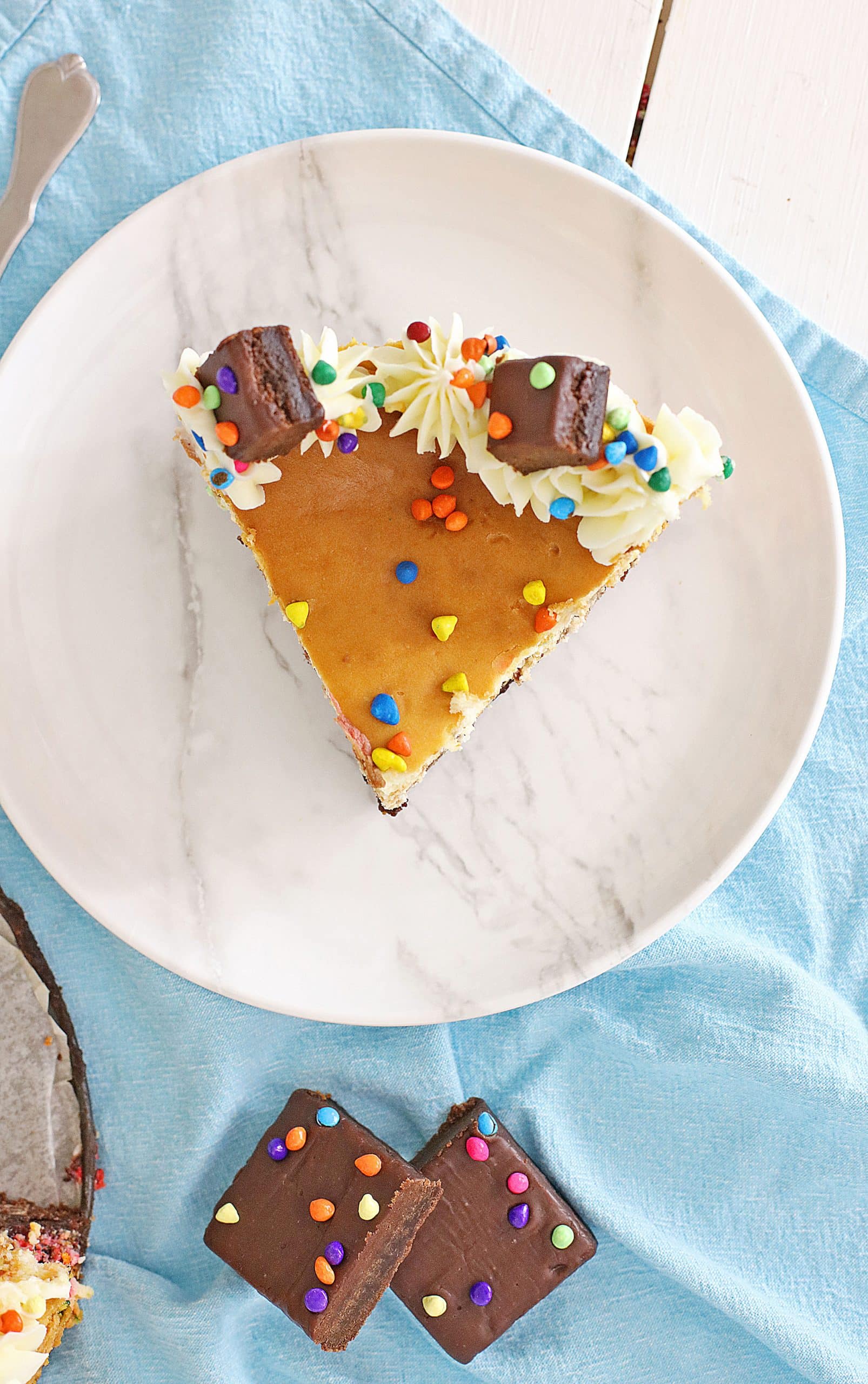 a slice of cosmic brownie cheesecake on a small white plate