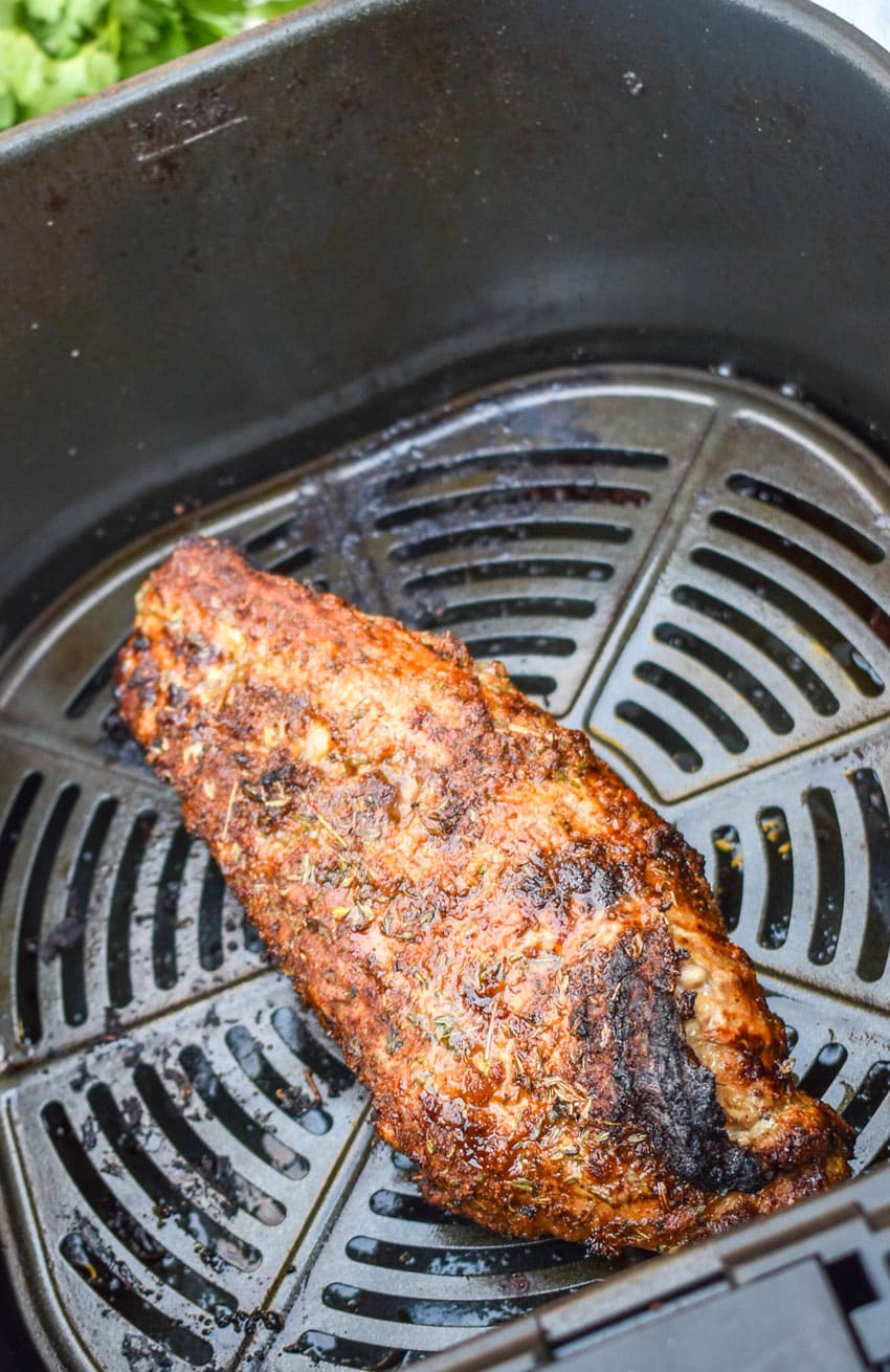 an air fried pork tenderloin in the basket of an air fryer