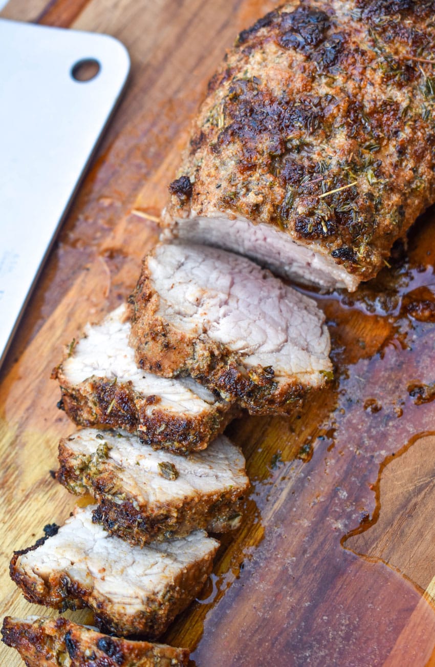 an air fried pork tenderloin cut into slices and resting on a wooden cutting board