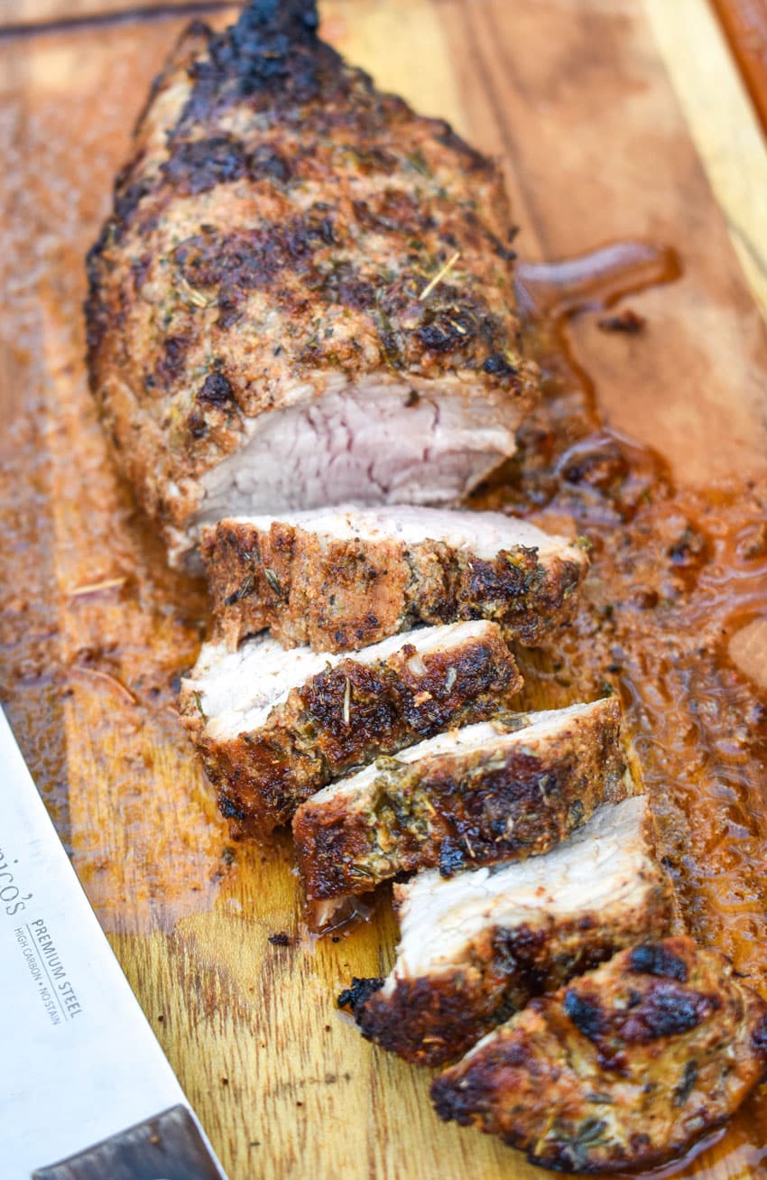 an air fried pork tenderloin cut into slices and resting on a wooden cutting board