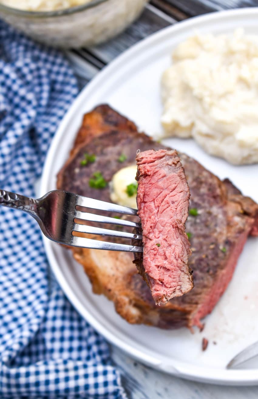 a silver fork holding up a slice of medium air fried steak