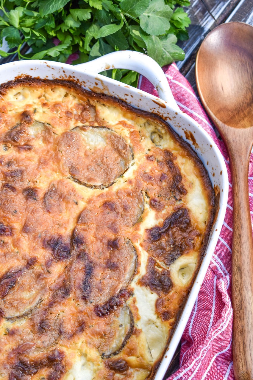 creamy scalloped potatoes with boursin cheese in a large white casserole dish