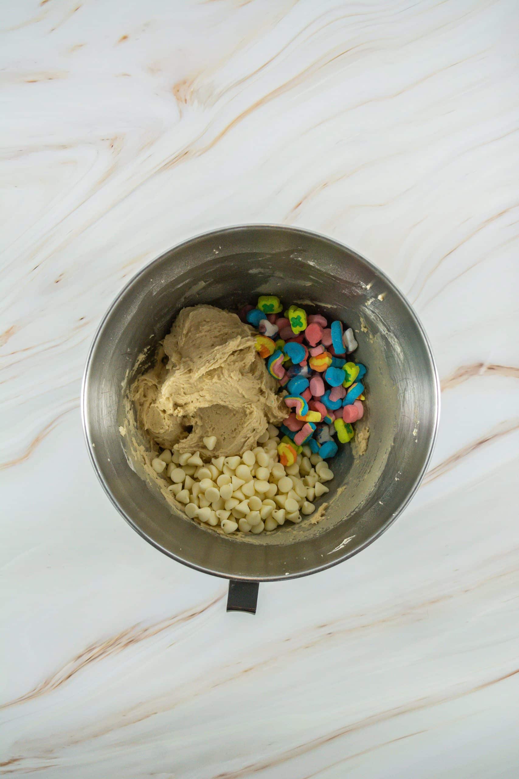 lucky charms cookie dough in a metal mixing bowl