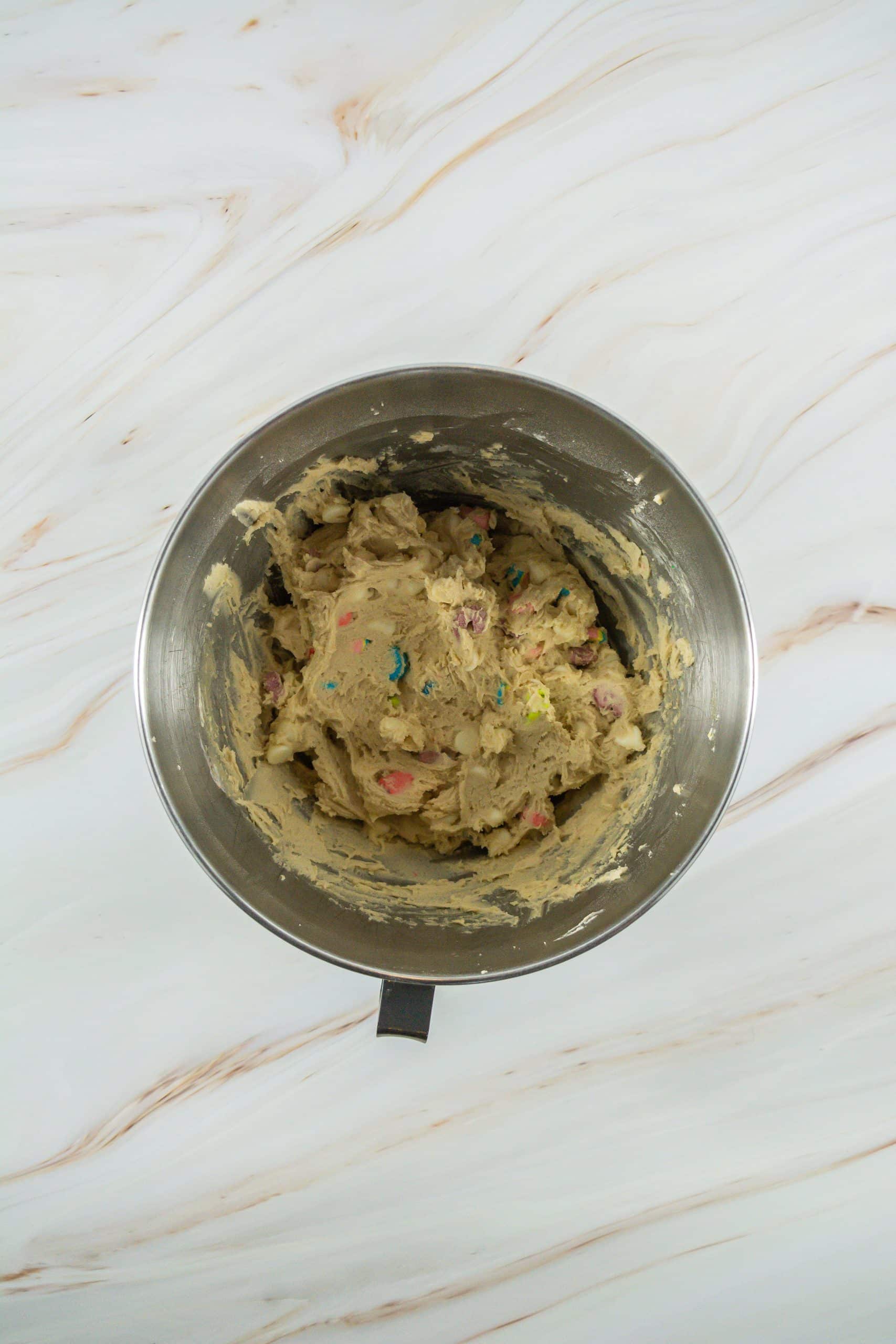 lucky charms cookie dough in a metal mixing bowl