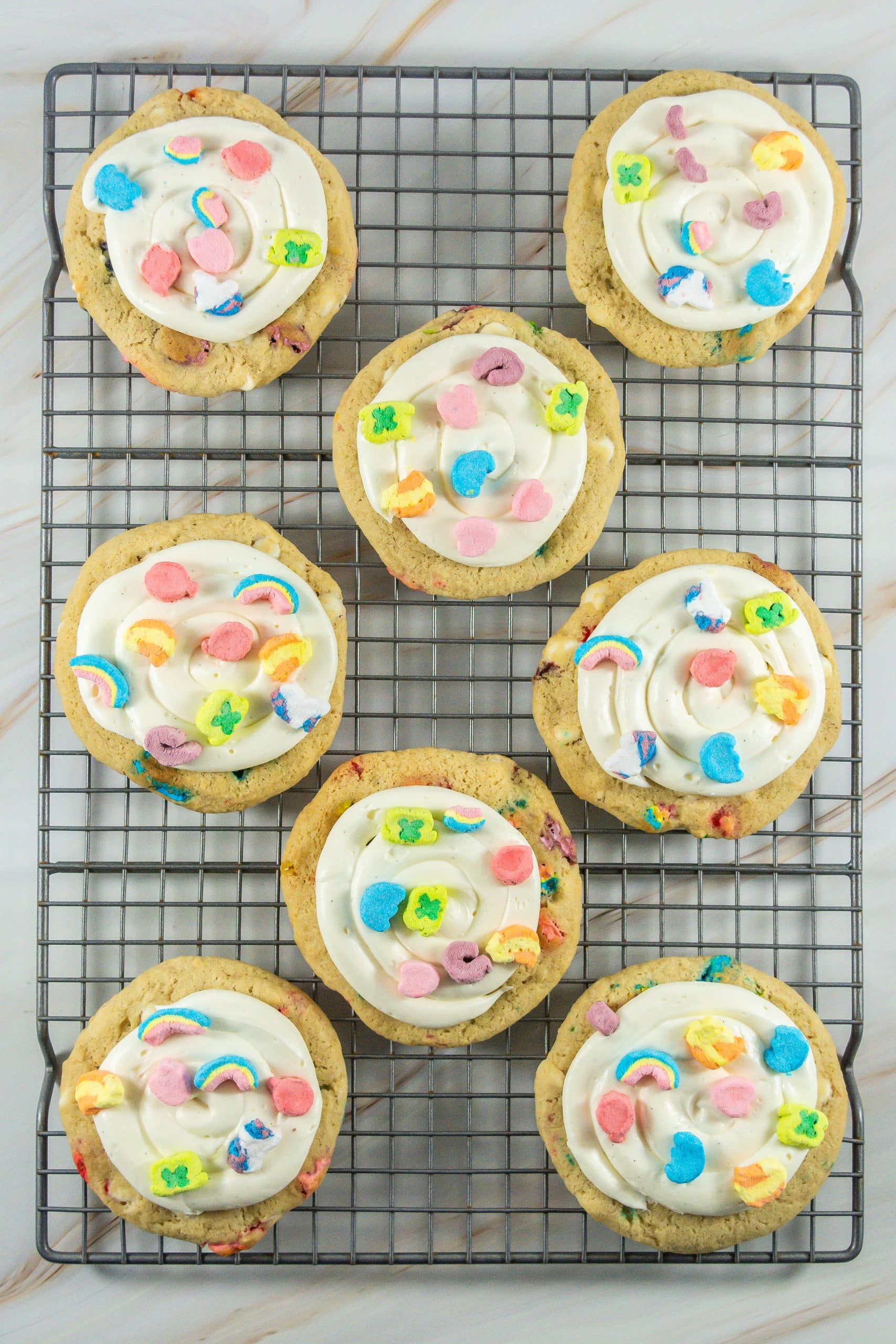 frosted lucky charms cookies on a wire cooling rack