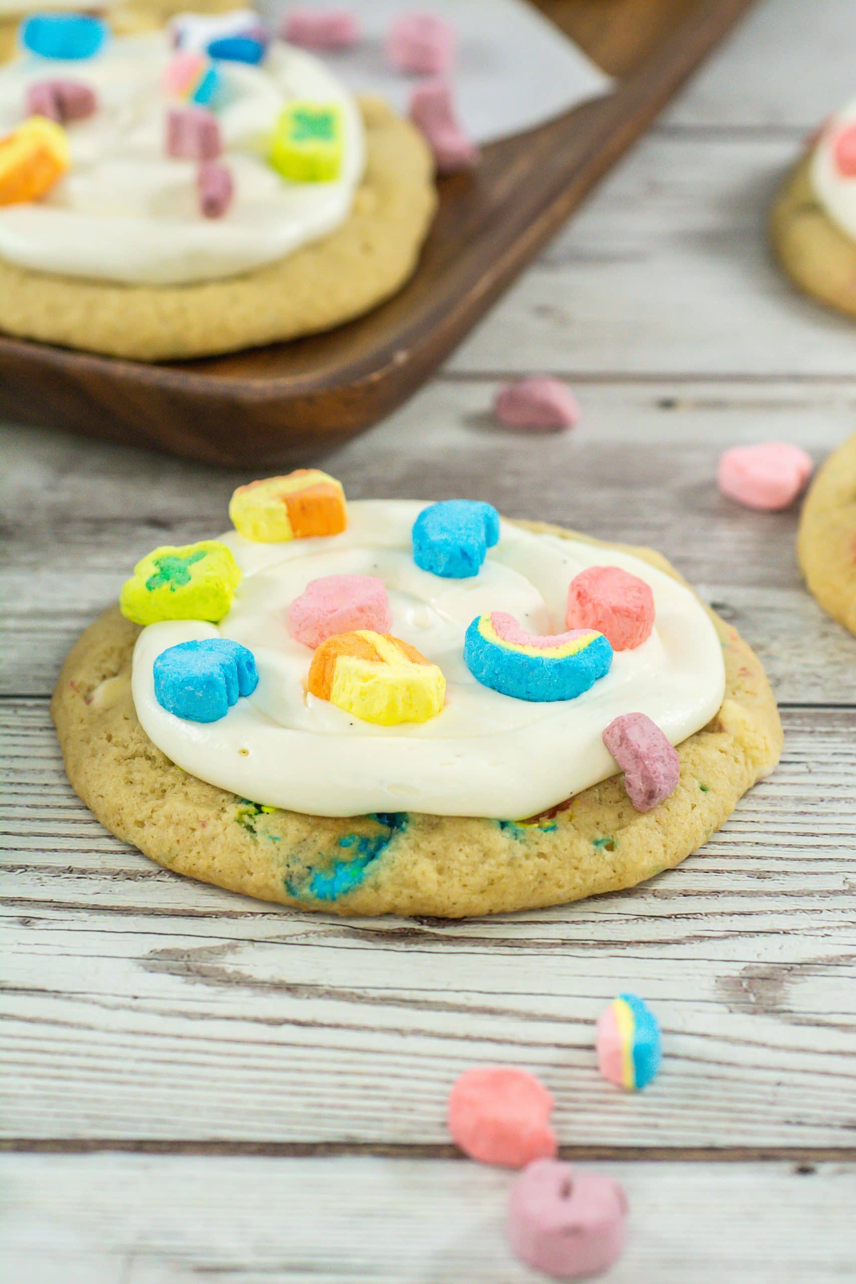 a frosted lucky charms cookie sitting on a wooden table