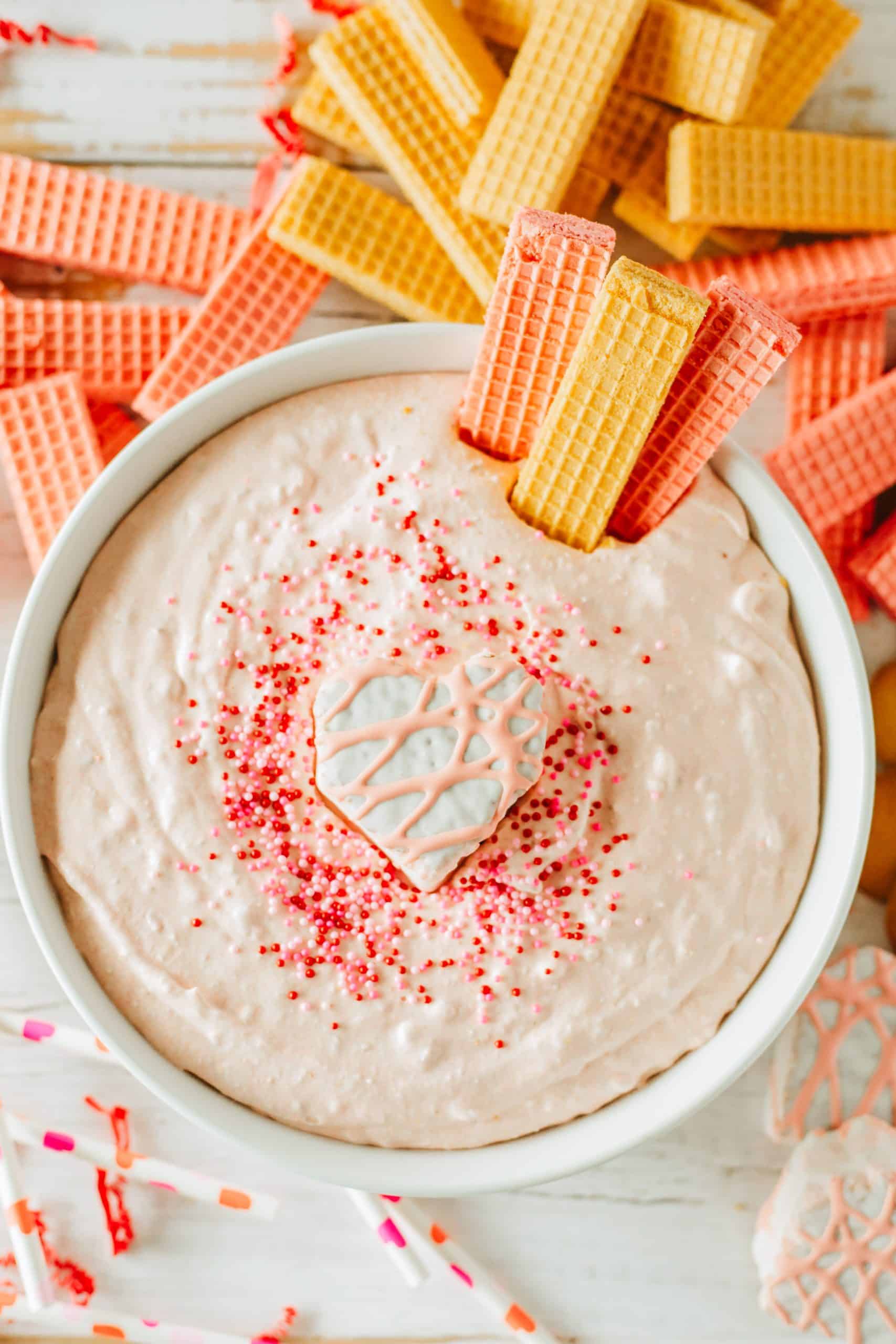 Little Debbie Valentine cake dip in a white bowl topped with sprinkles and a snack cake