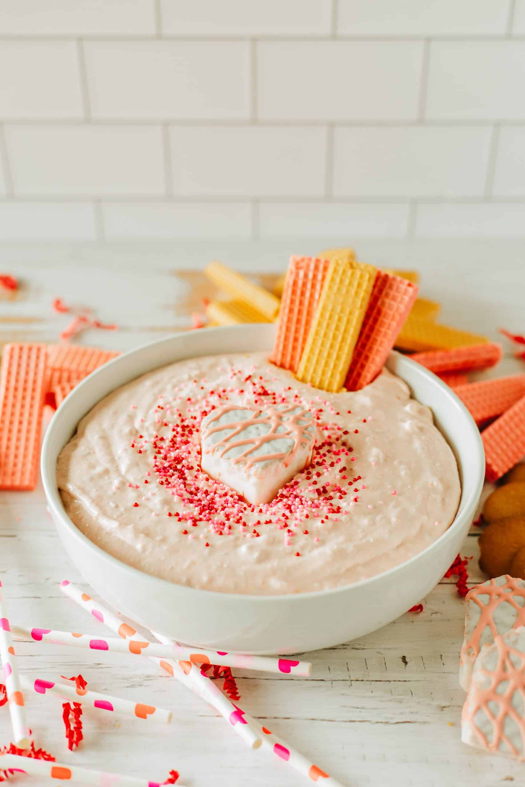 Little Debbie Valentine cake dip in a white bowl topped with sprinkles and a snack cake