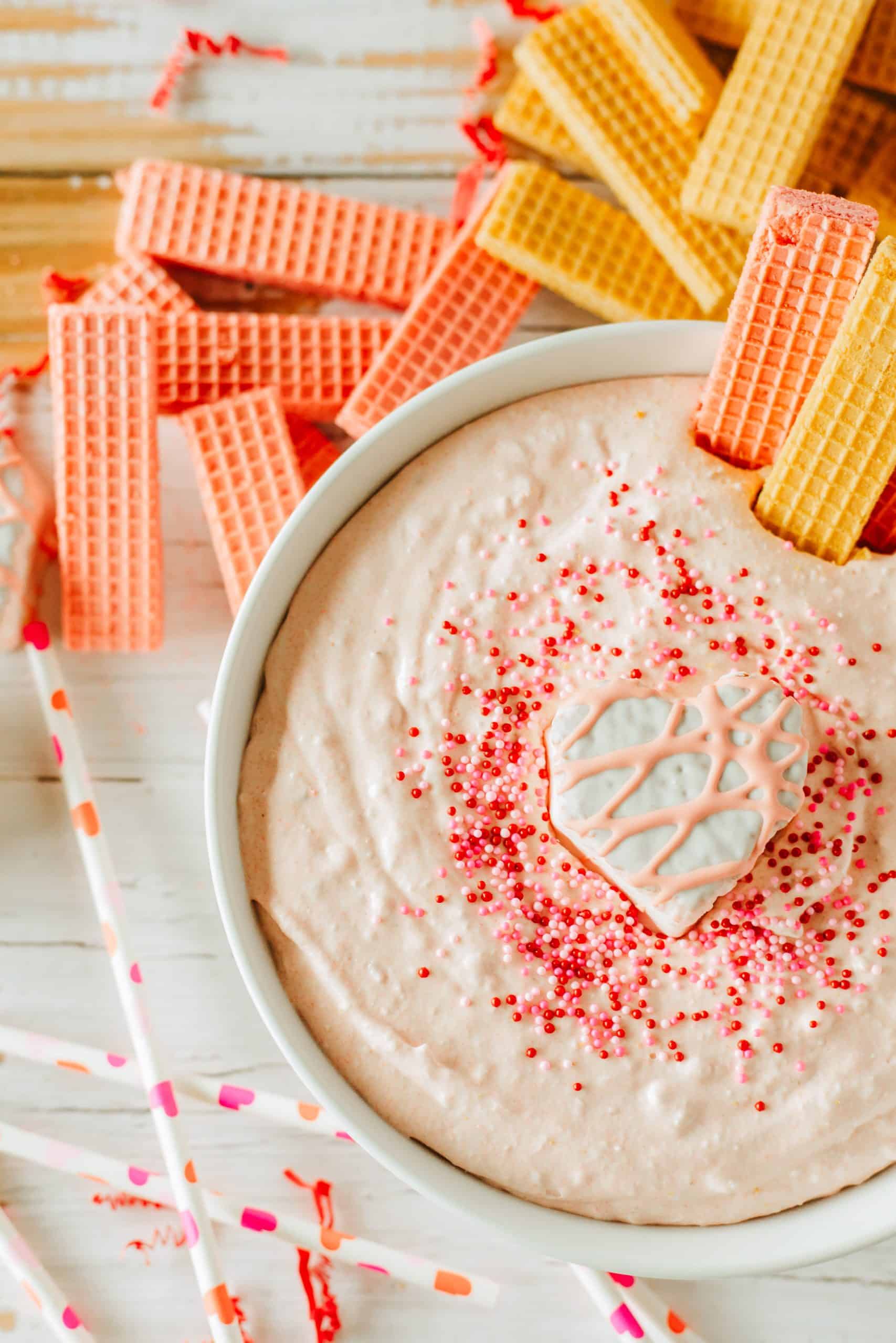 Little Debbie Valentine cake dip in a white bowl topped with sprinkles and a snack cake