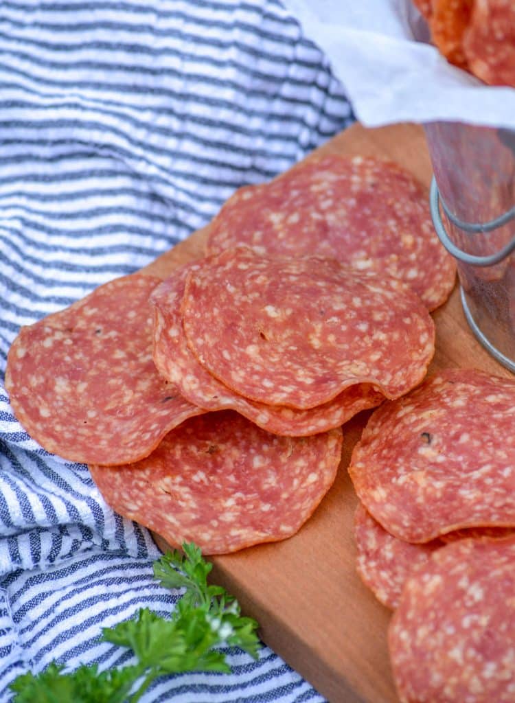 salami chips on a wooden cutting board