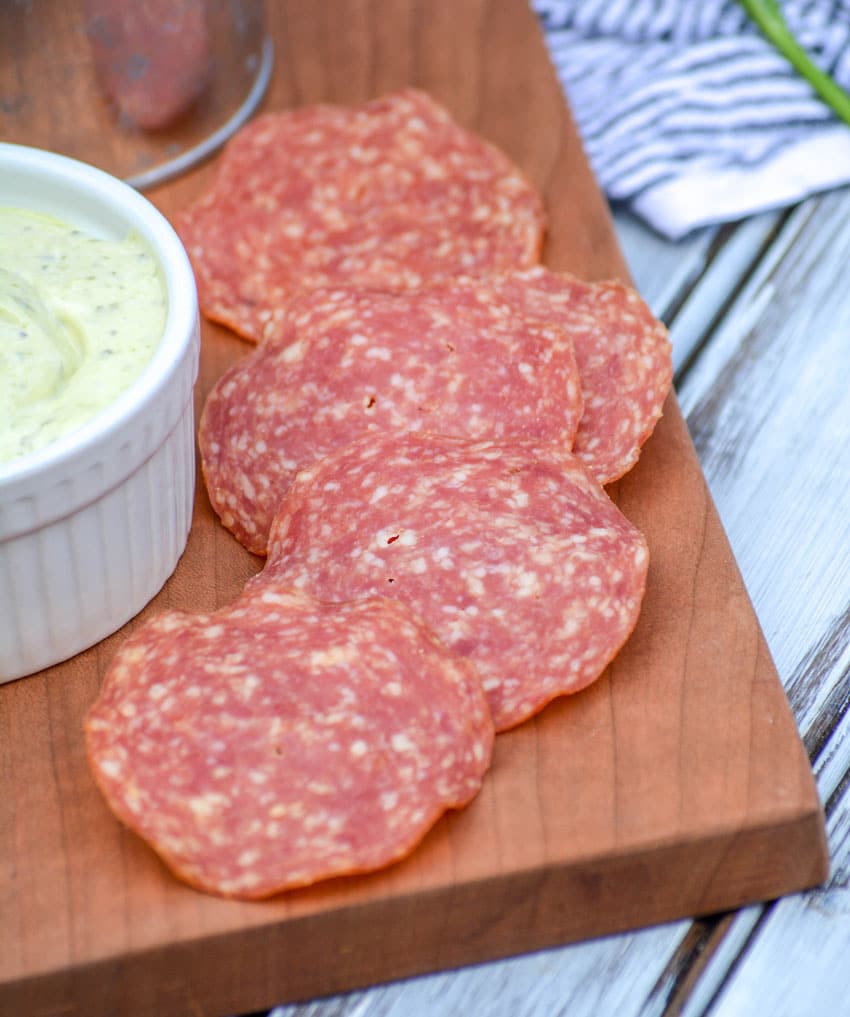 salami chips on a wooden cutting board