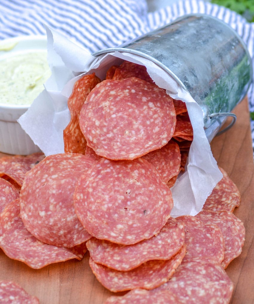 salami chips on a wooden cutting board