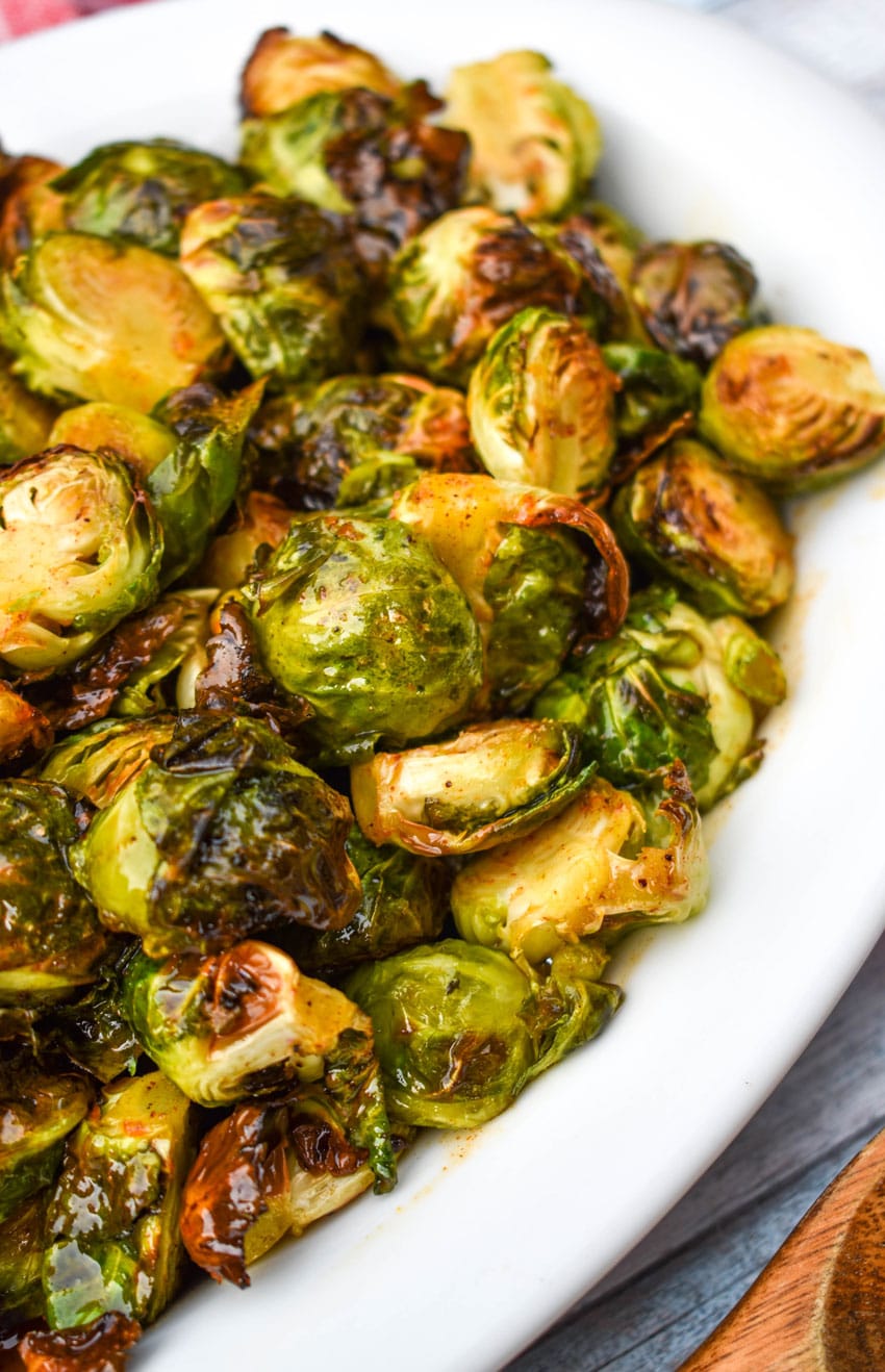 air fryer brussels sprouts in a white serving dish on top of a red cloth napkin