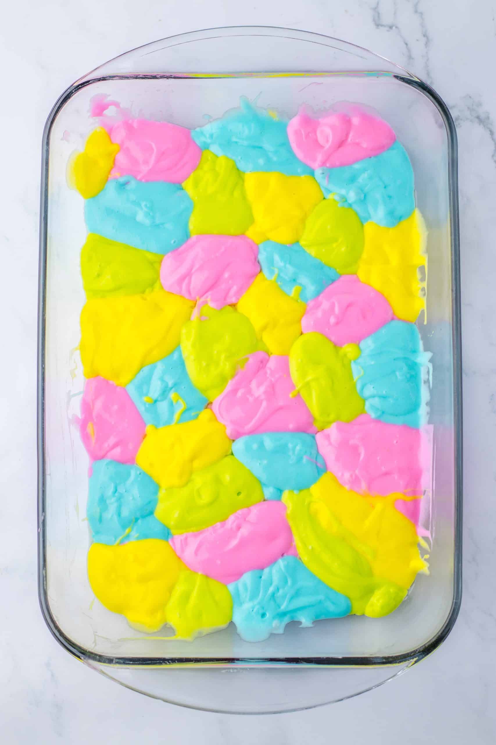 pastel colored dollops of cake batter in a 9x13 inch glass baking dish