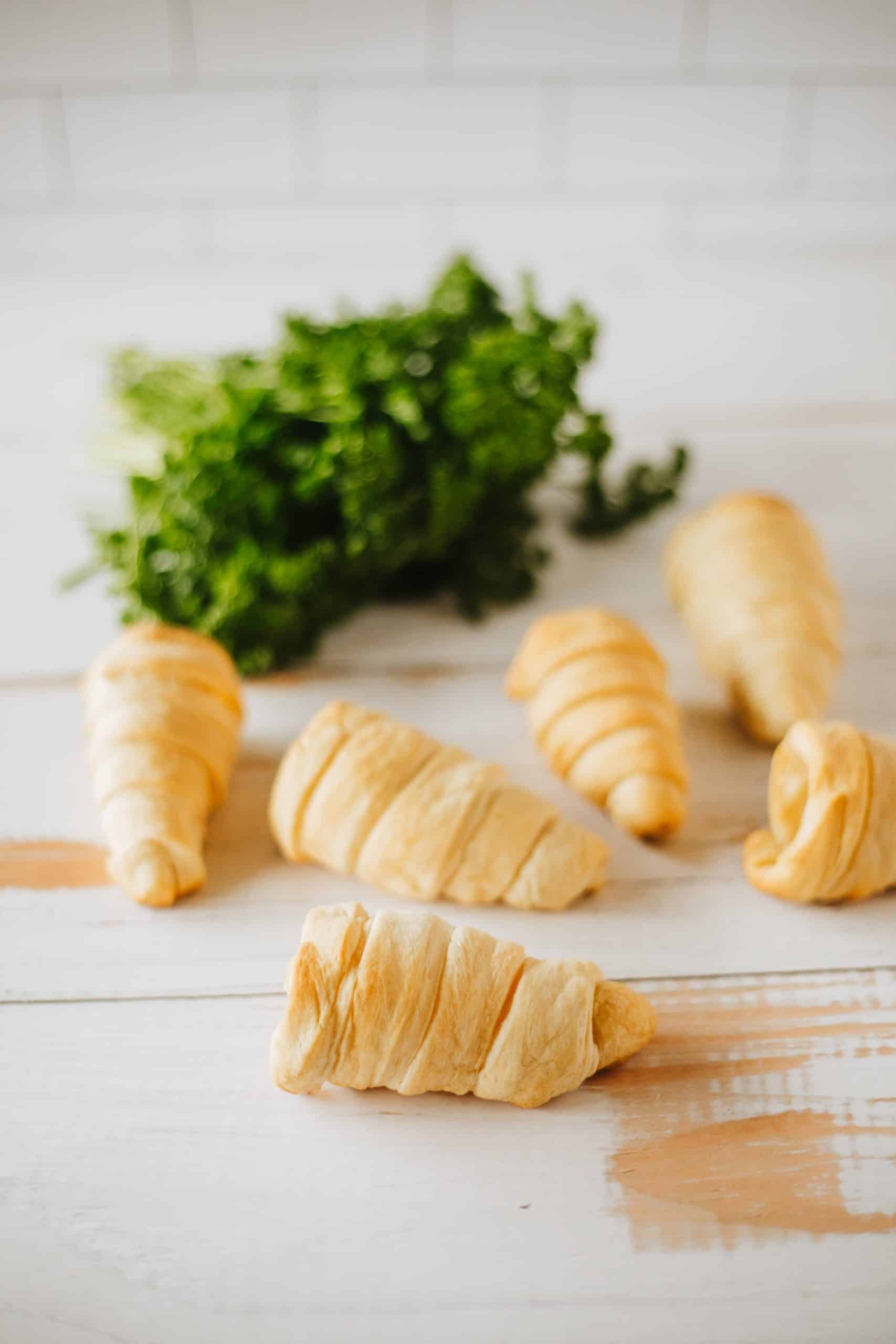 baked crescent roll cones on a wooden cutting board